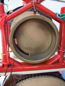 A kane drum attached to a red metal frame.